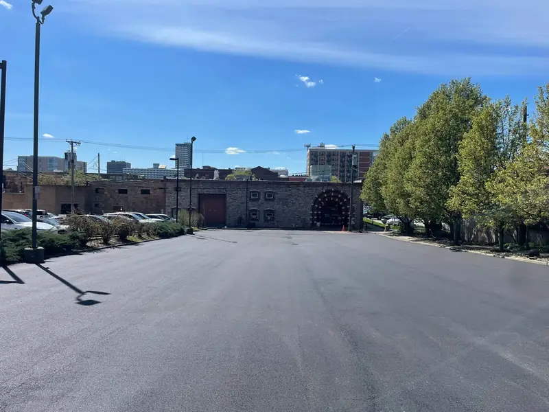 Freshly paved downtown parking lot leading to a historic stone building