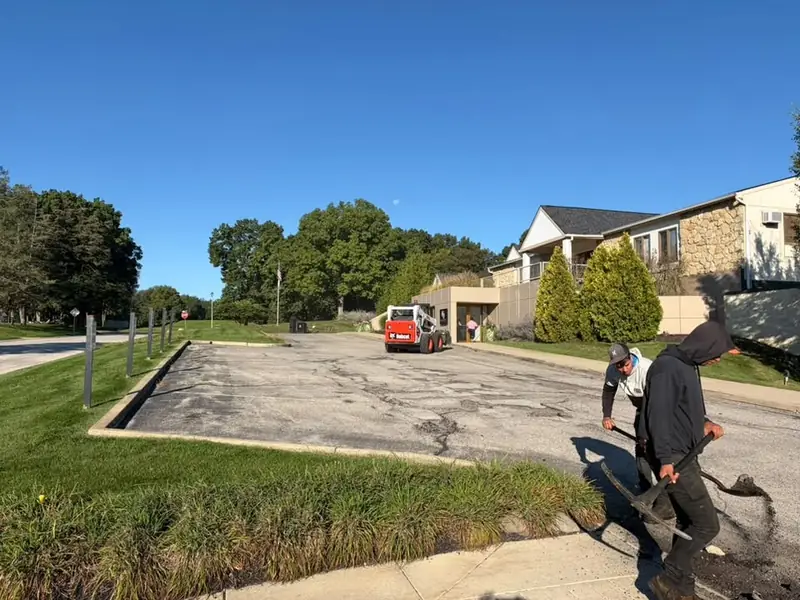 Before: crew digging out failed spots in the cracked front drive at Knollwood Country Club