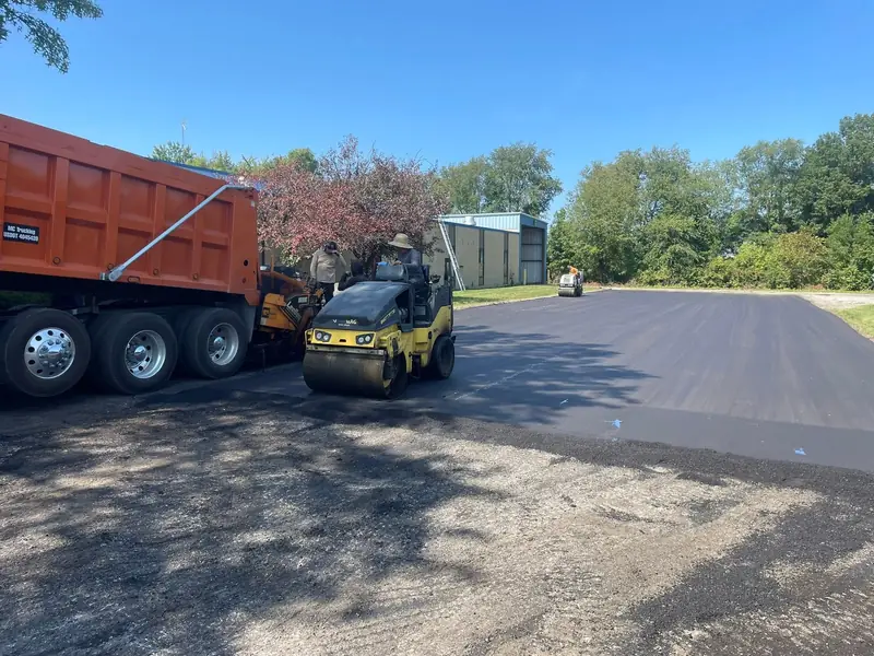 Roller and dump truck working a new section of a commercial lot
