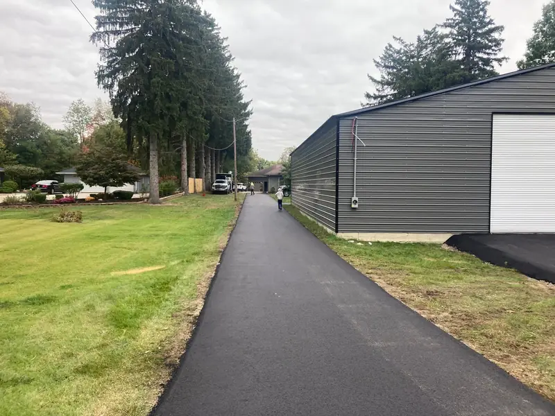 After: a new asphalt drive running alongside the same steel building